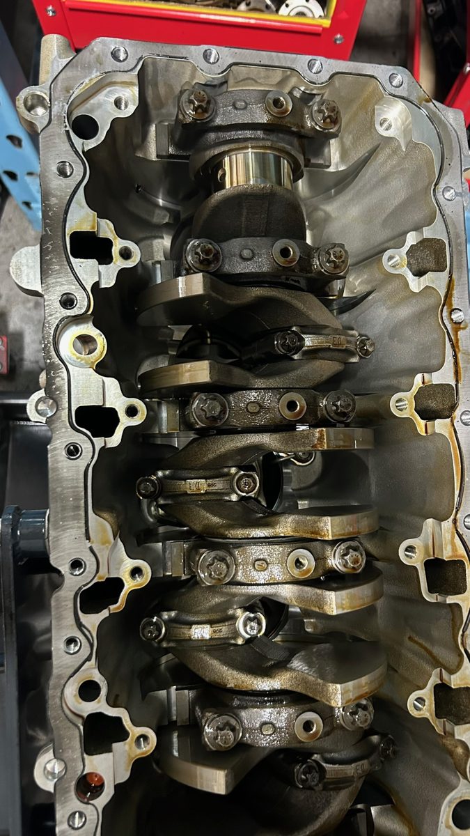S58 bottom end as received during teardown, main caps and crankshaft in place